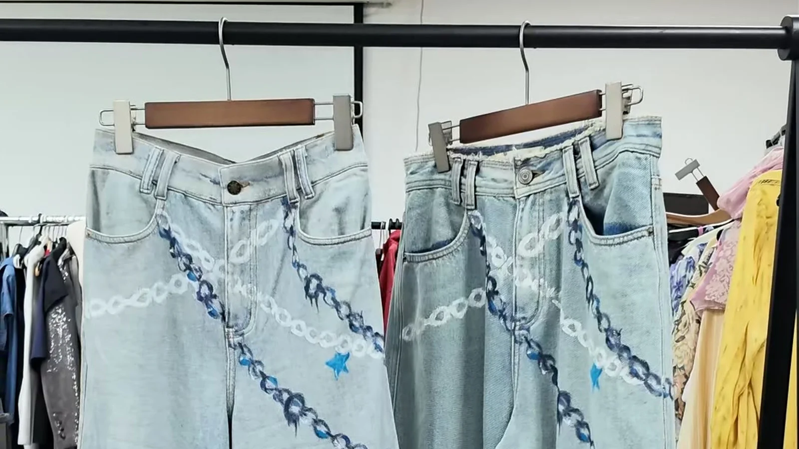 Two light blue faux-denim French Terry trousers with printed chain graphics at Shengfu