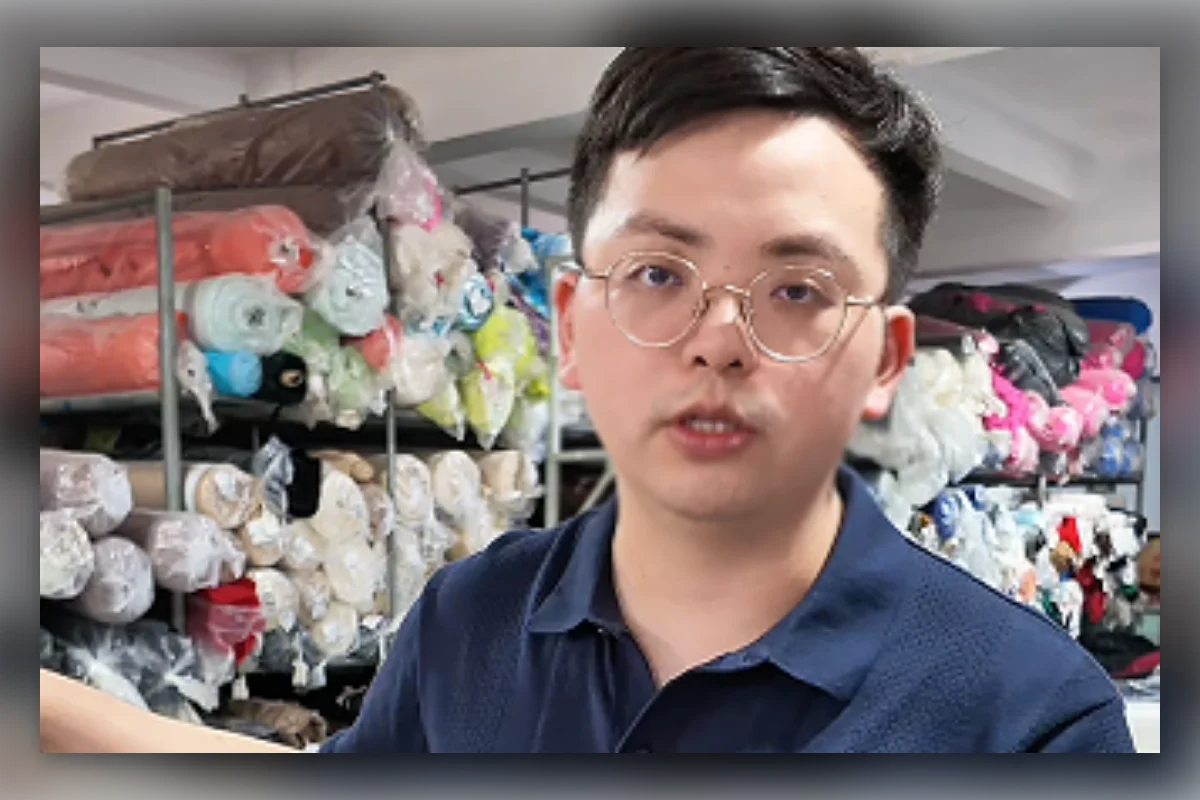 Shengfu garment developer explaining MOQ and fabric sourcing in the factory warehouse