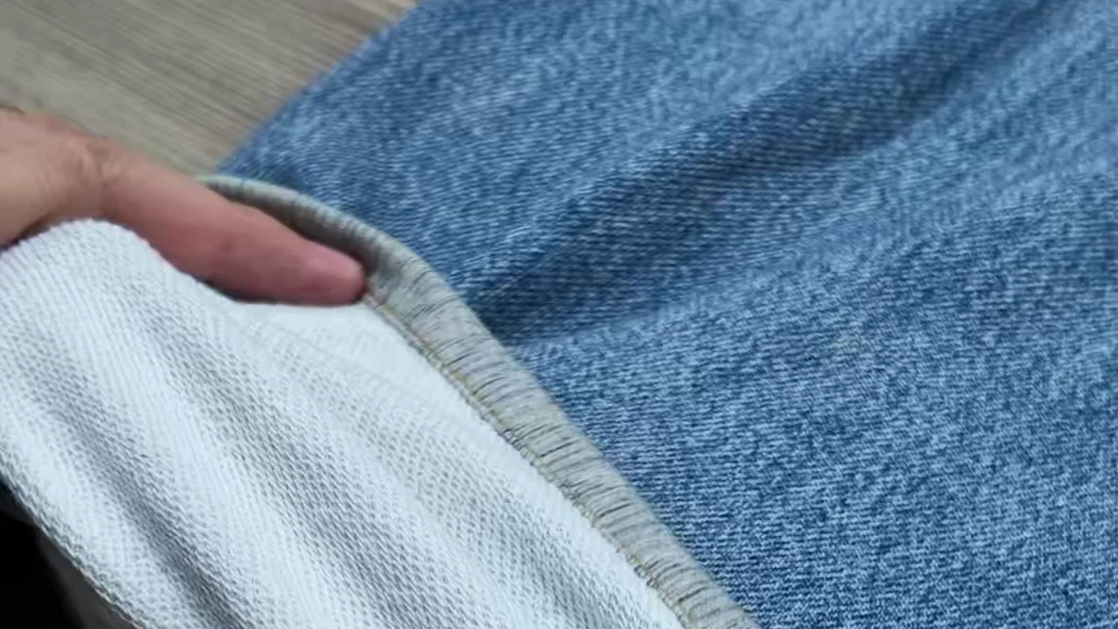 Close-up comparing printed denim-look fabric face and white loop-back French Terry interior