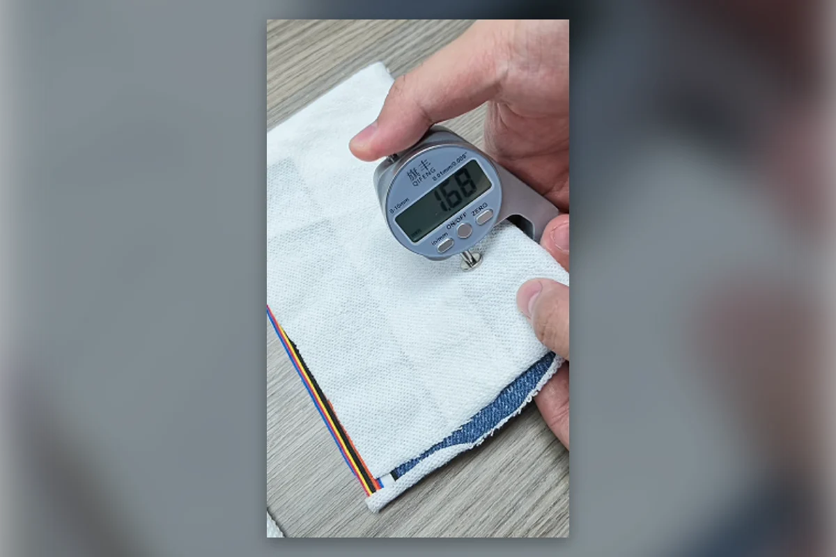 Shengfu technician checking fabric GSM before confirming a garment quote