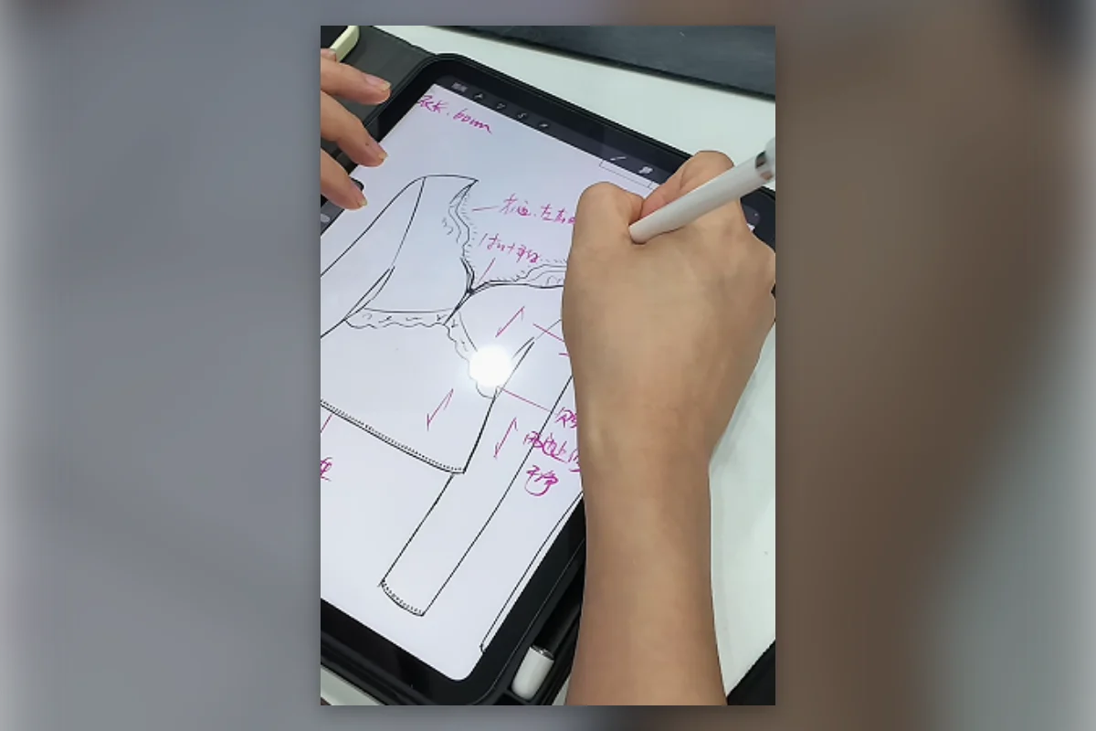 Garment technician adding point of measure and construction notes to a digital Tech Pack drawing