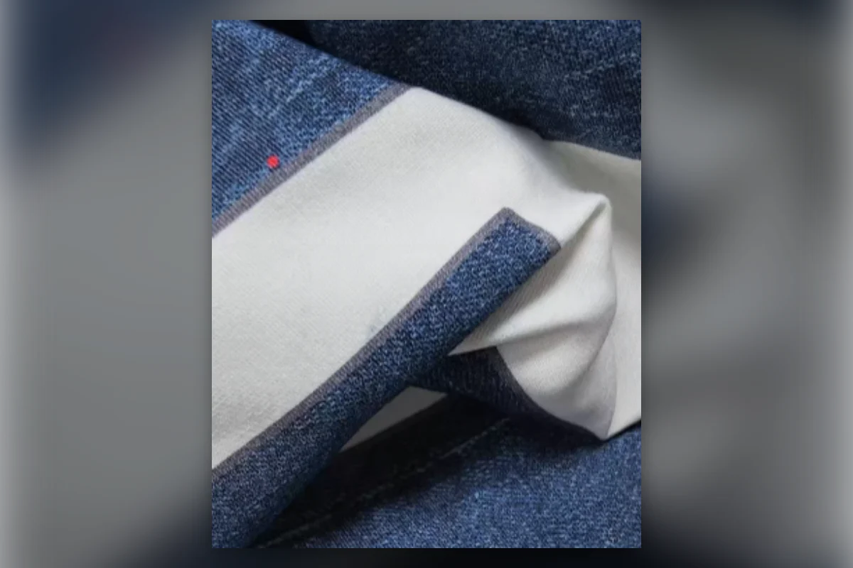 Printed blue denim-look surface opened to show the light knit fabric backing