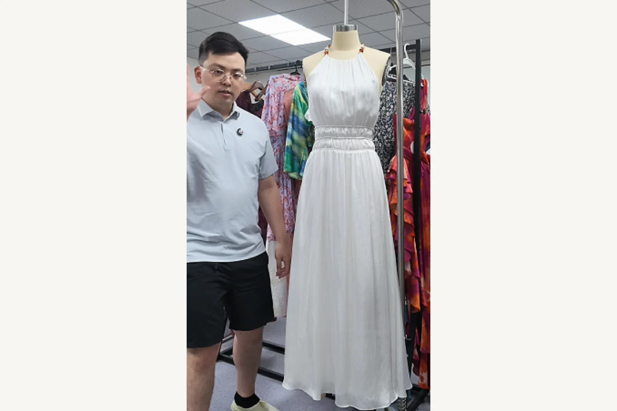 Shengfu reviewing a custom dress sample before a bulk production payment