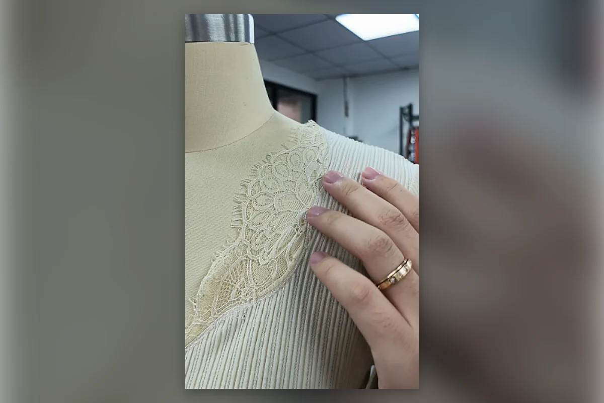Close-up of lace placement and neckline construction on a rib-knit womenswear sample