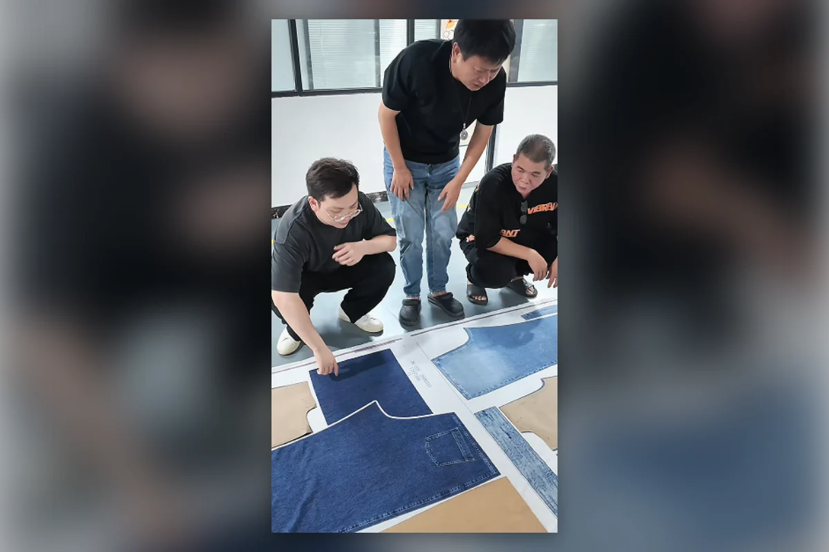 Shengfu development team reviewing faux denim artwork and garment pattern panels