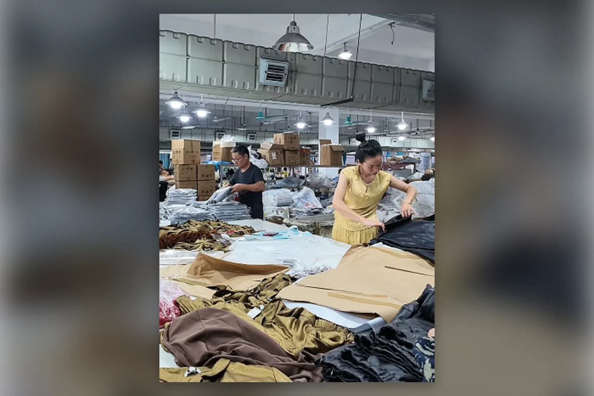 Workers handling and sorting garments at production tables