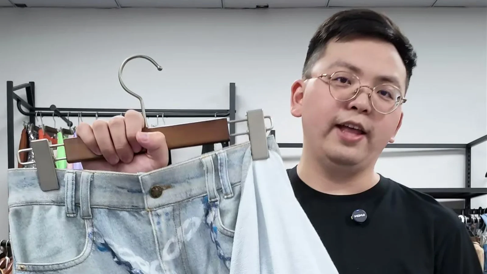 Shengfu product developer holding printed French Terry faux-denim trousers and showing the fabric interior