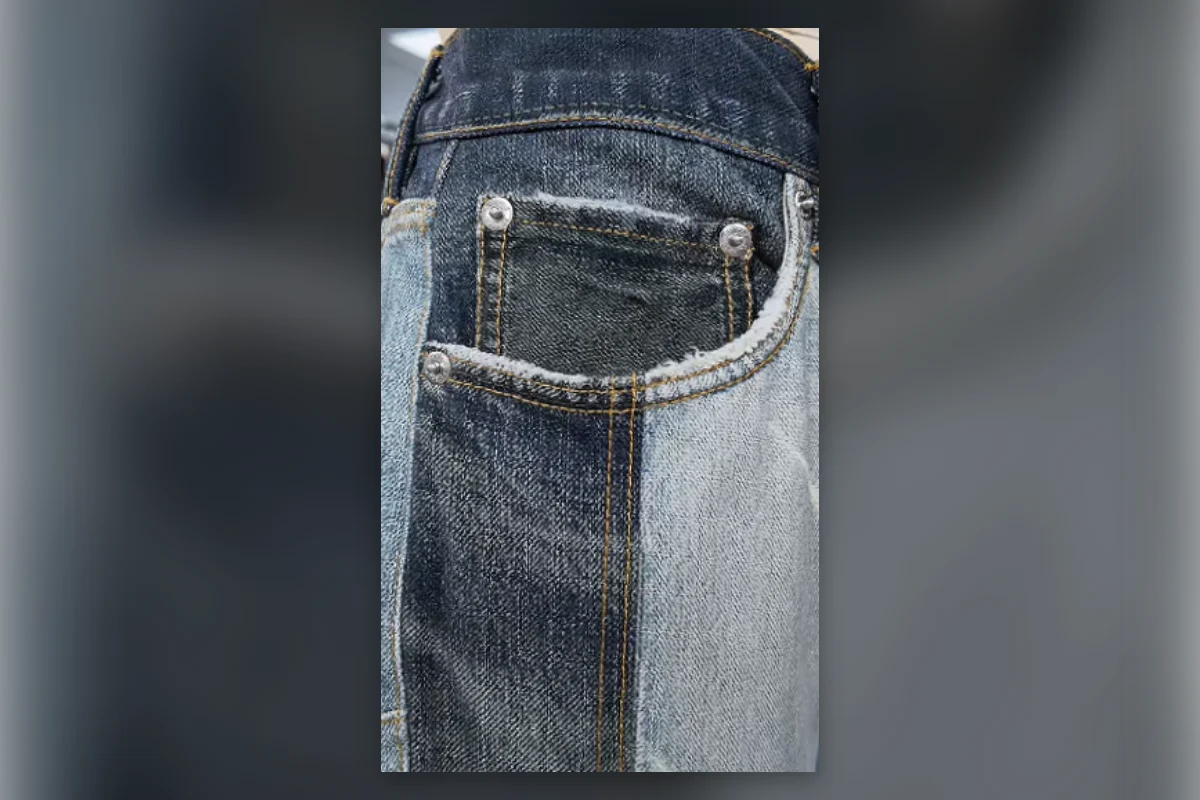 Close-up of printed pocket stitching and wear effects on faux denim fabric