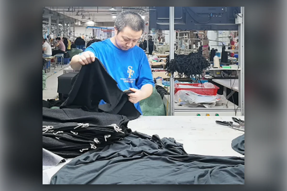 Shengfu quality technician reviewing garments during production