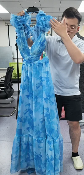 Team member reviewing a blue printed dress sample