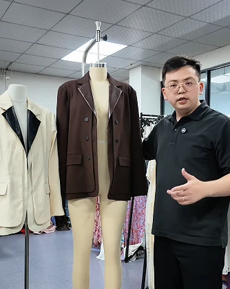 Tailored garments on forms during a sample discussion