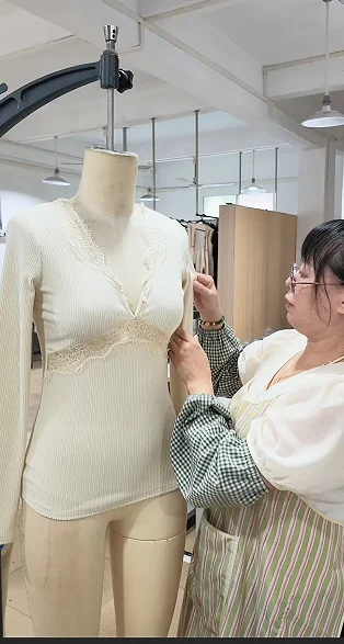 Team member examining a garment on a dress form