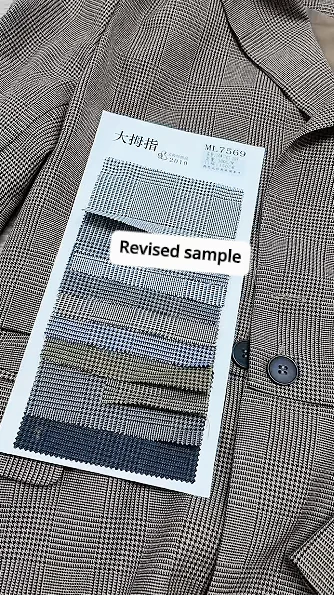 Fabric card labelled revised sample beside a garment