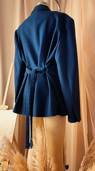 Illustrative rear view of a navy jacket with a waist tie