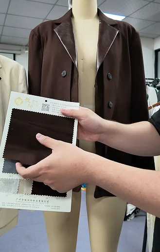 Fabric and colour references held beside a jacket sample