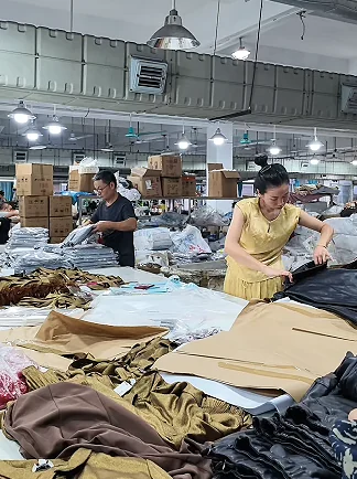 Workers handling garments at a production table