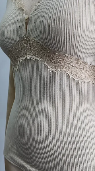 Lace detail on a pale ribbed garment neckline