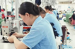 Worker sewing at a garment production station