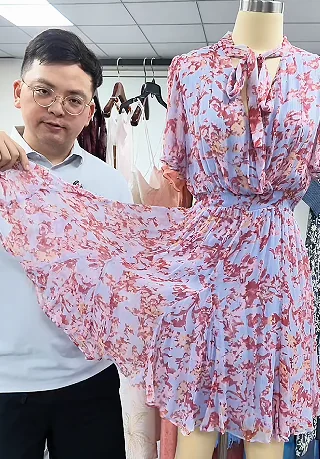 Printed fabric held beside a floral dress sample