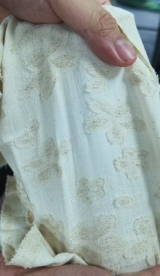 Hand lifting pale textured fabric