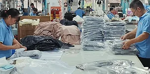 Workers handling packed garment stacks