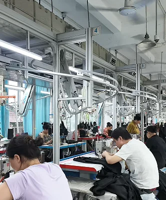 Workers seated along a garment sewing line