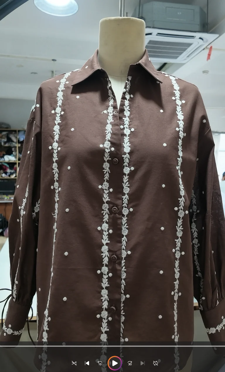Brown embellished blouse on a dress form