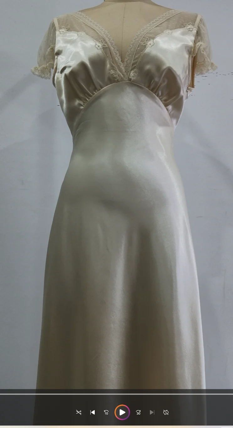 Light-coloured dress with gathered neckline on a dress form