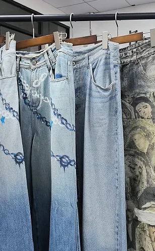 Several jeans with different surface appearances on hangers