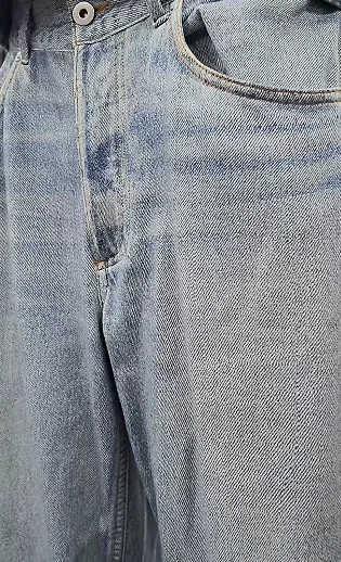 Close-up of a jeans front with faded-looking areas