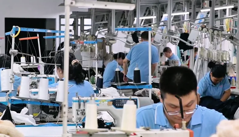 Worker sewing at a garment production workstation