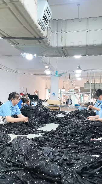 Garment finishing area with dark garments on tables