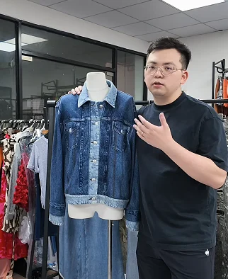 Man discussing a denim-style vest on a form
