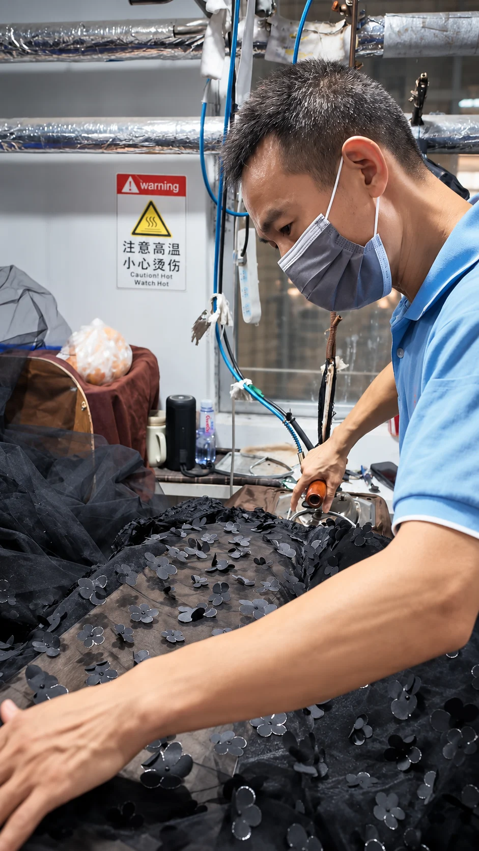Worker handling dark garments at a worktable
