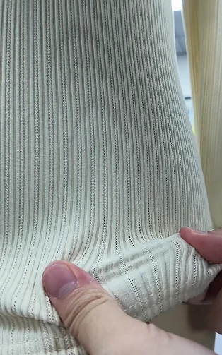 Hand opening a pale ribbed fabric